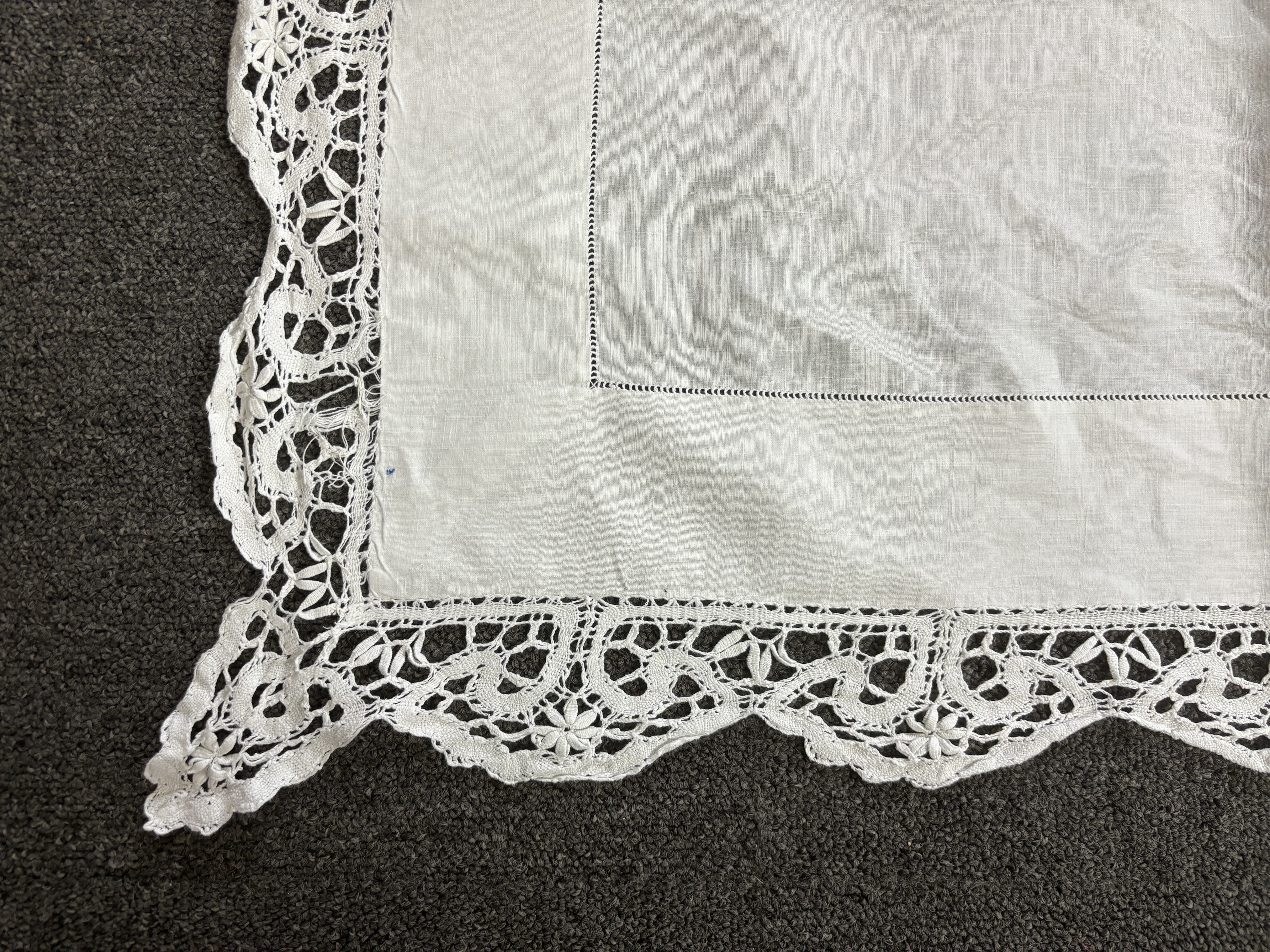 An Edwardian damask banqueting cloth 354cm long x 232 wide, worked with a central needle lace inserted cartouche, together with a smaller linen table cloth, 264cm long x 226cm wide, bordered with bobbin lace edges and si